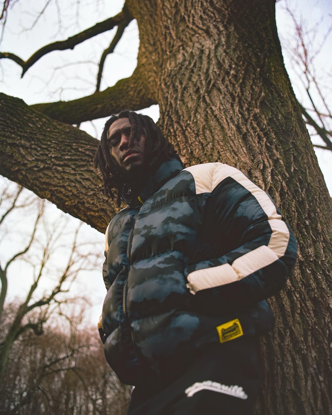 Dreamville lookbook. Camo puffer under bare tree