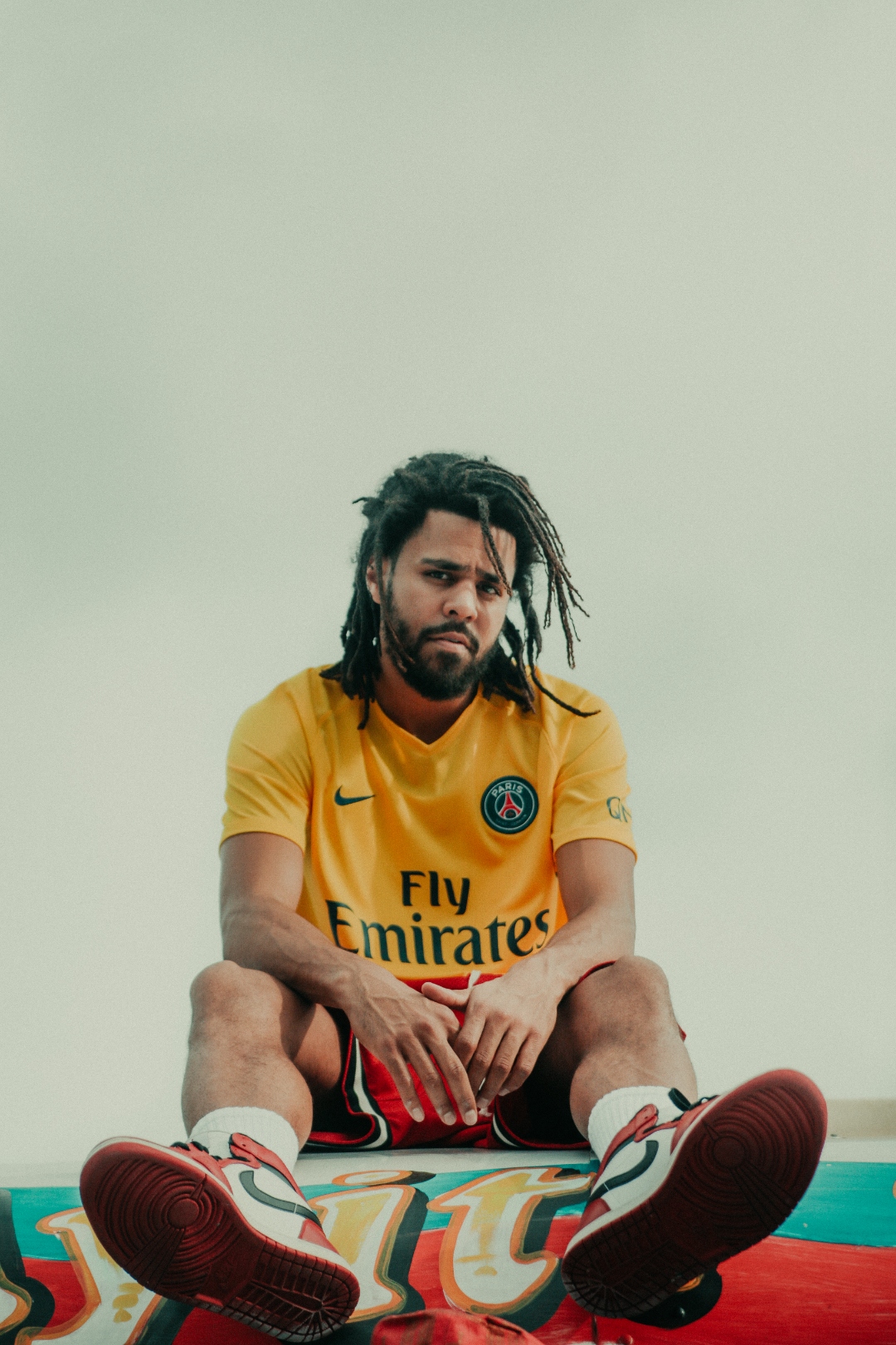 J. Cole in yellow PSG jersey