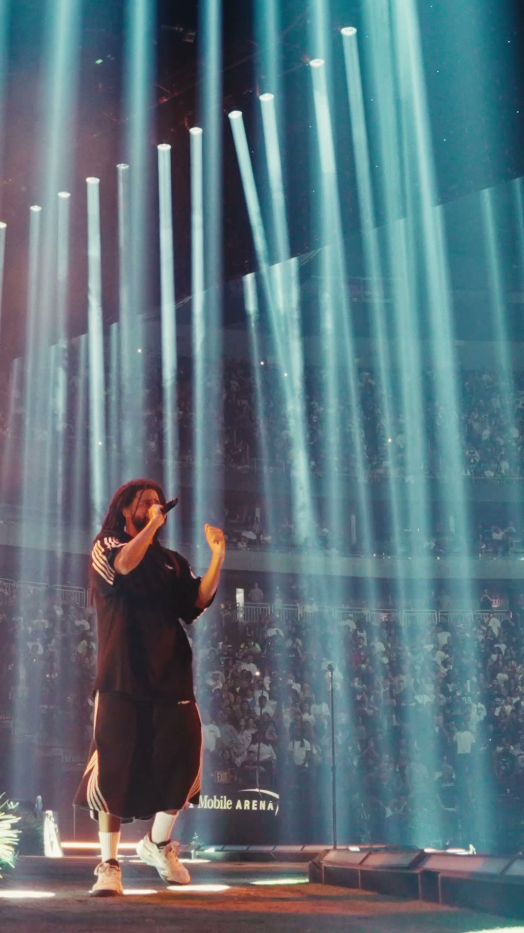 Wide shot of J. Cole under vertical light beams